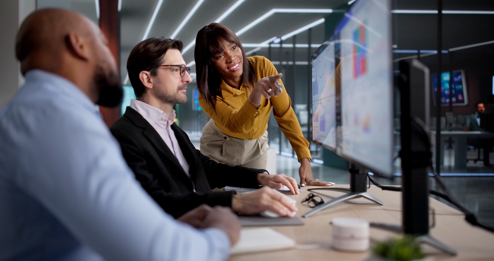 Enterprise team collaborating around dashboards in a modern office